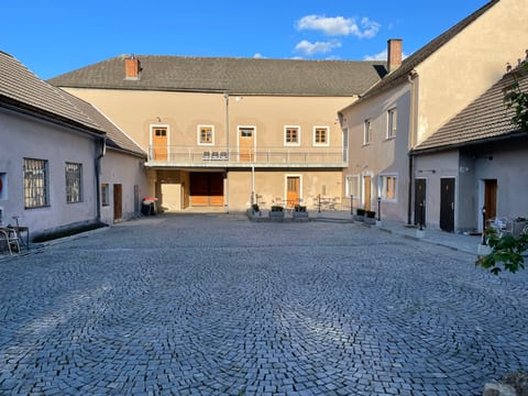 Innenhof mit Torbogen und beleuchteten Fenstern am Abend