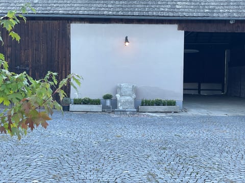Gepflasterter Innenhof mit Pflanzen und Bistrostühlen